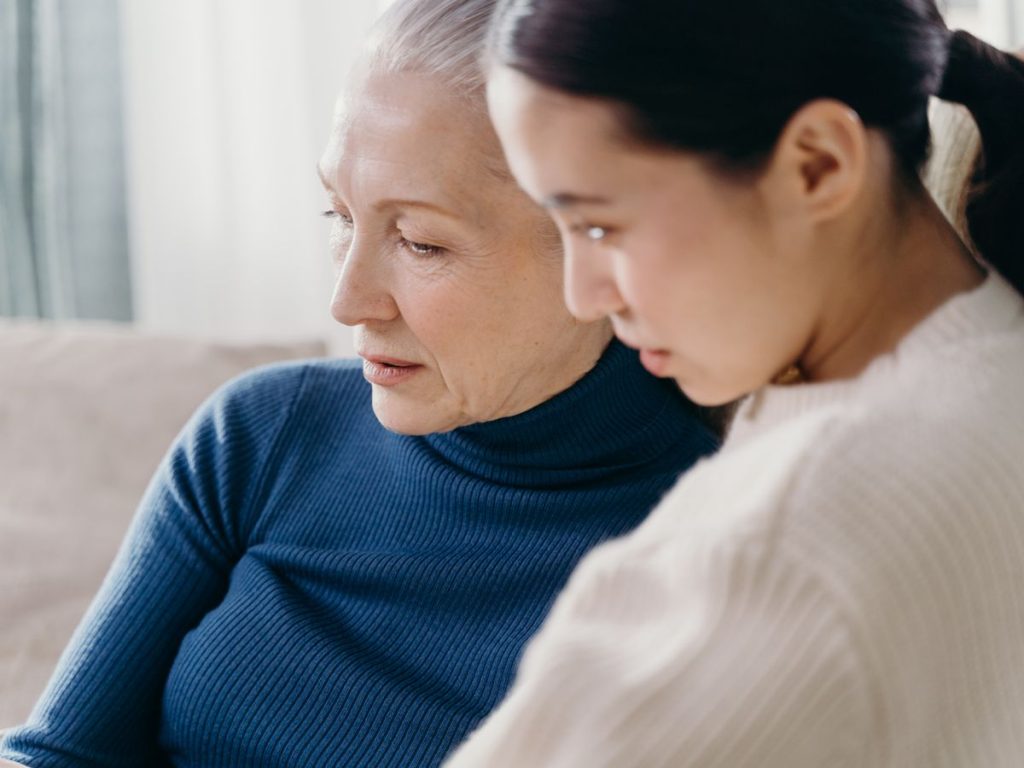 A loving bond between an elderly woman and a younger adult indoors