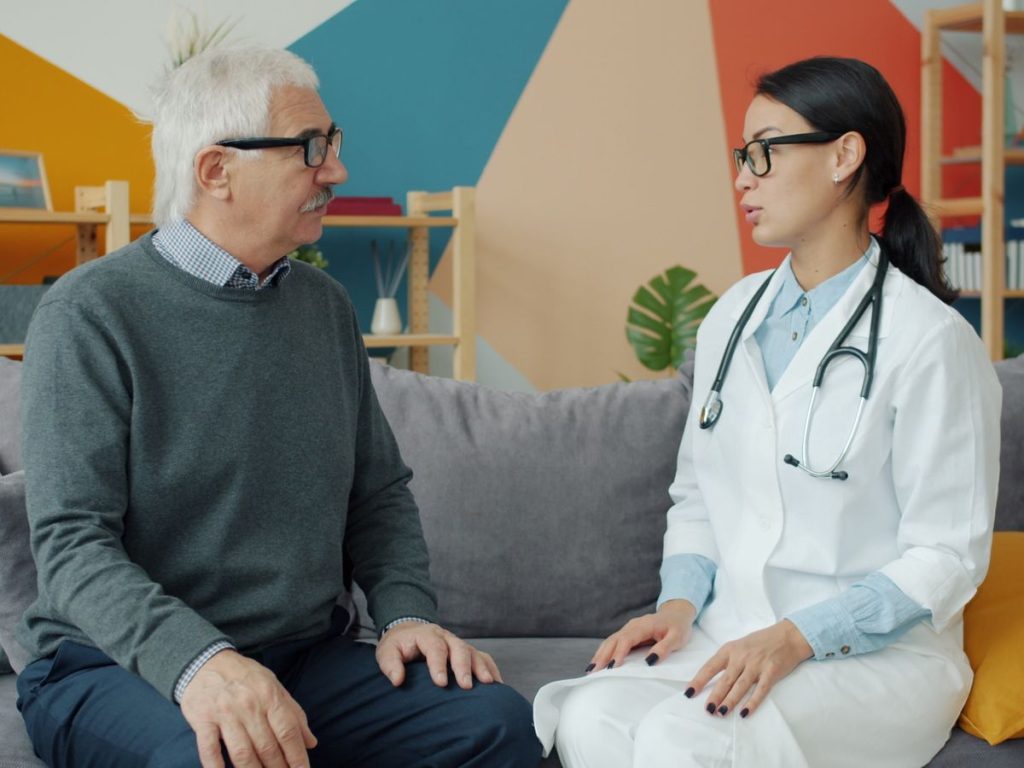 Senior man consulting with female doctor in a colorful office setting