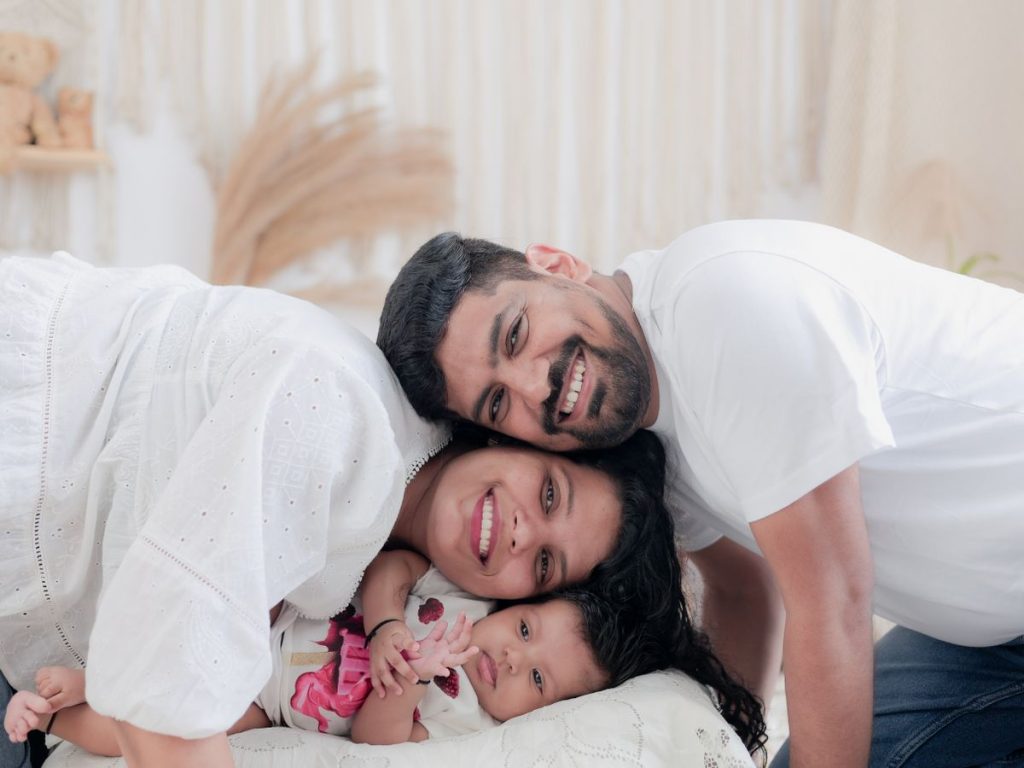 Joyful family cuddling together indoors, capturing a heartwarming moment with their baby