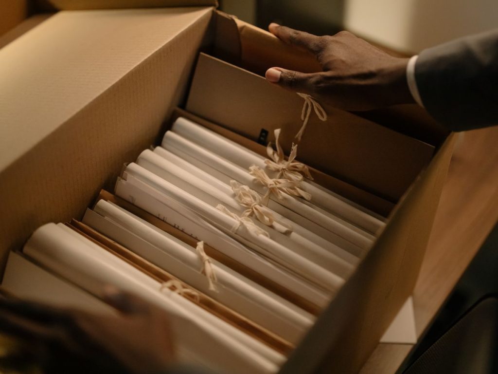 Hands organizing files in a box, symbolizing investigation and research