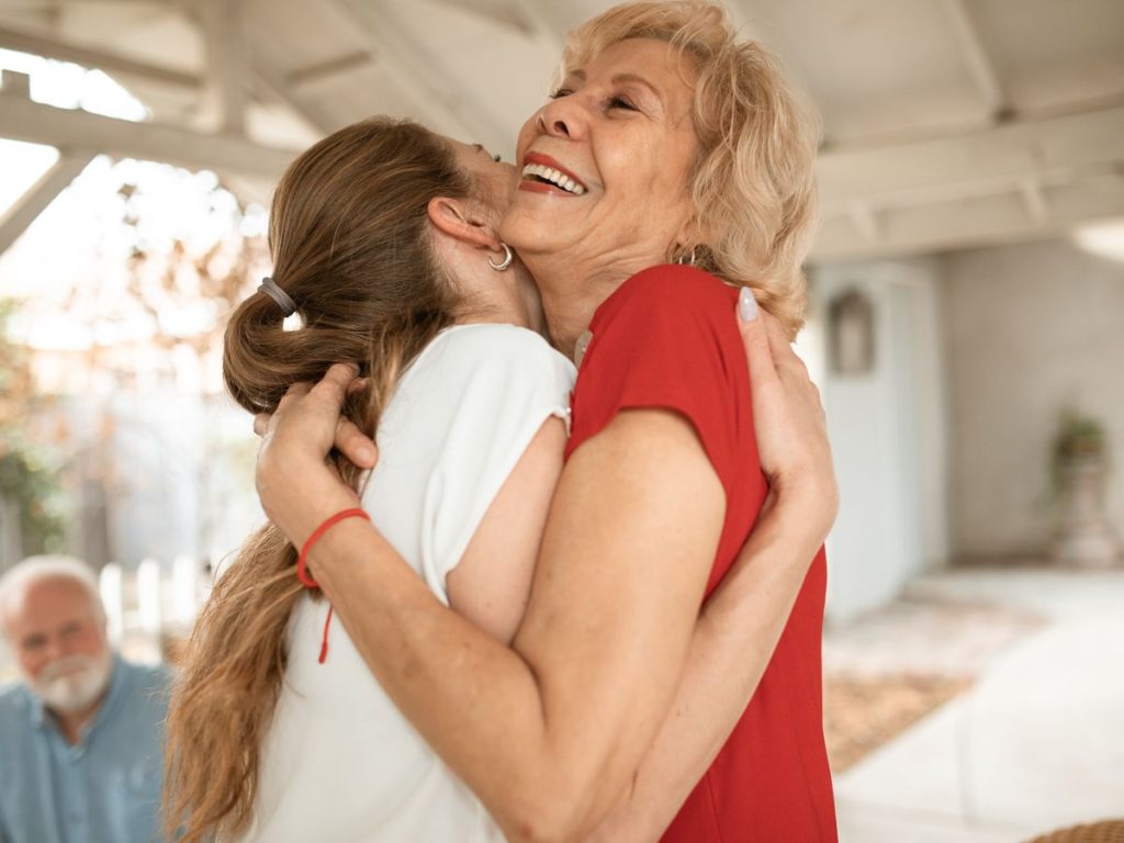 Adult daughter hugging her smiling mother