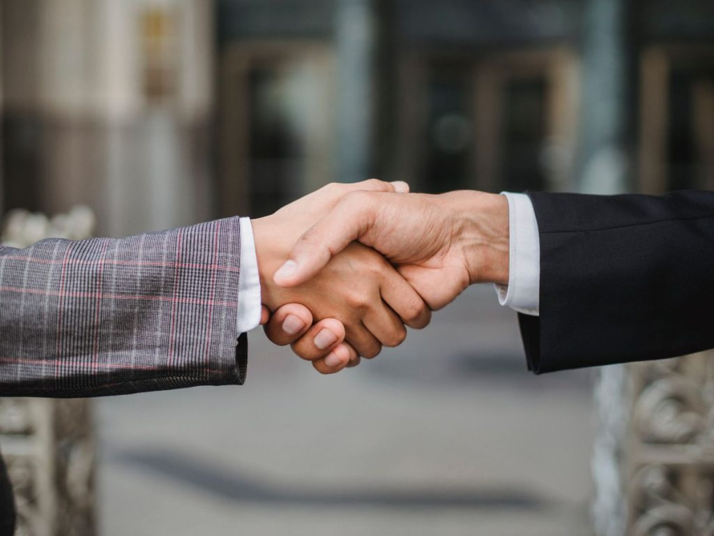A close-up of two businesspeople shaking hands, symbolizing cooperation and partnership