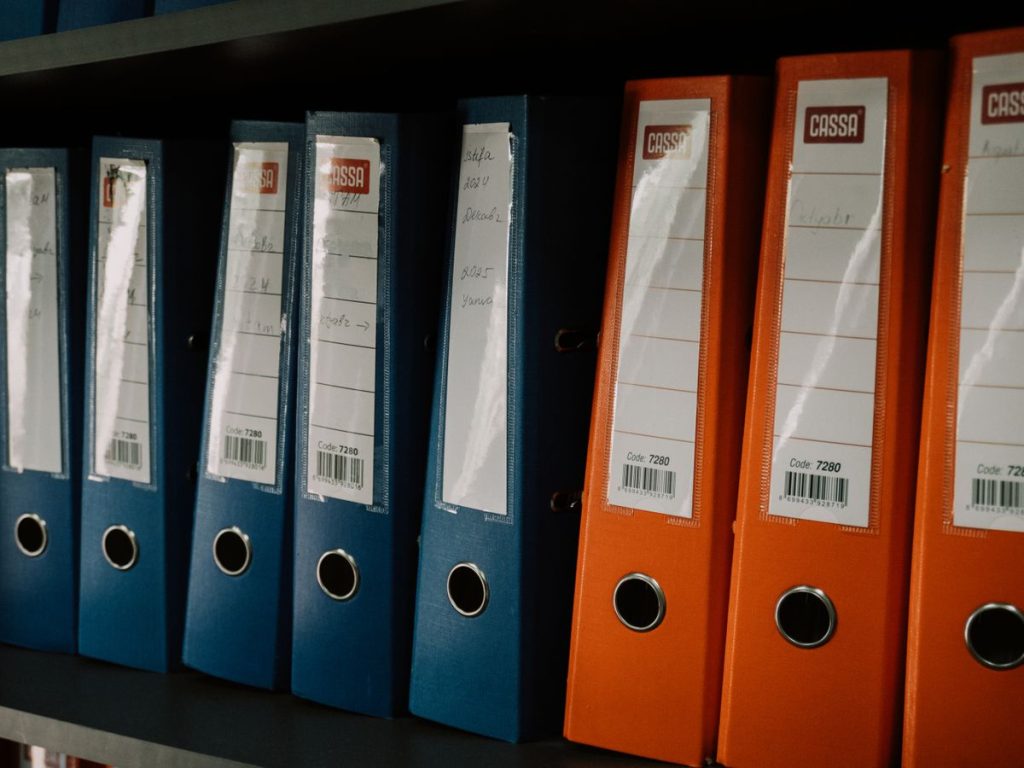 Row of colorful office binders neatly arranged on a shelf