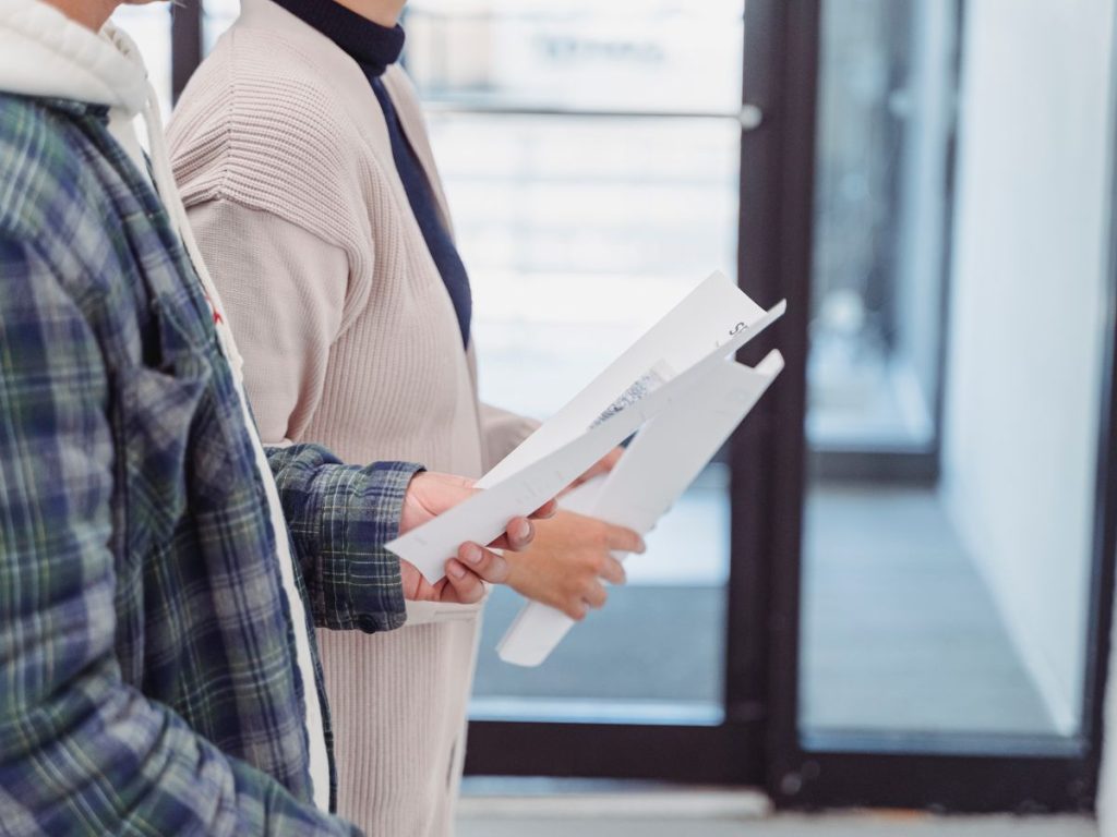 Two people standing indoors reviewing property documents