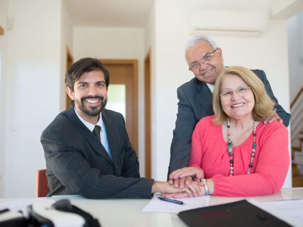 Smiling senior couple meeting with a professional advisor in a bright indoor setting