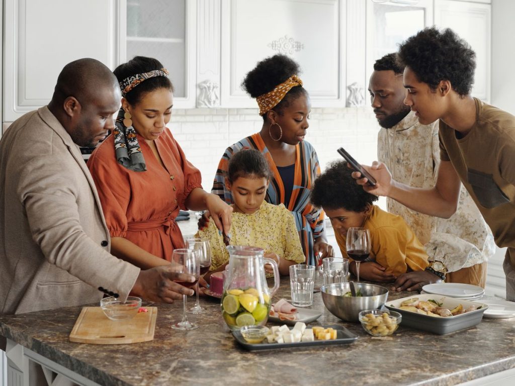 A joyful family gathering in the kitchen, enjoying food and drinks together