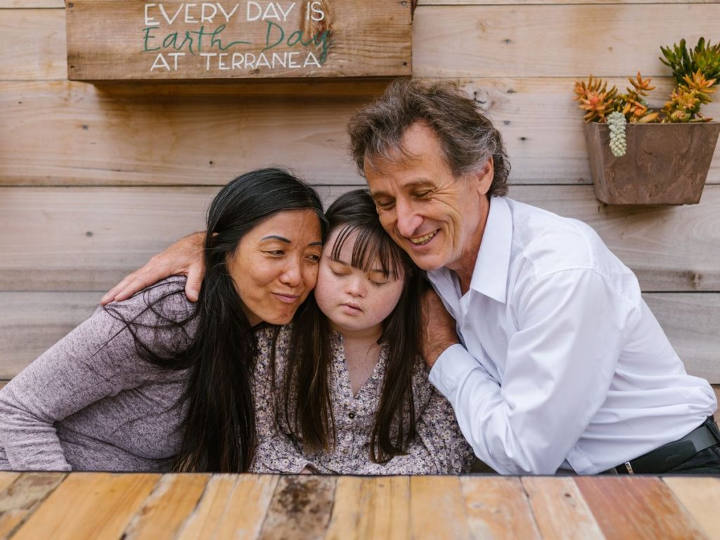 A family warmly embraces their daughter, showing love and support in an outdoor setting