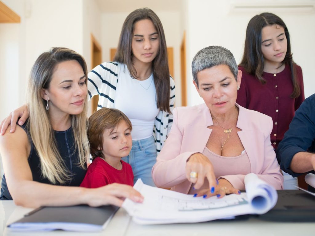 A family group reviewing real estate documents with a realtor indoors