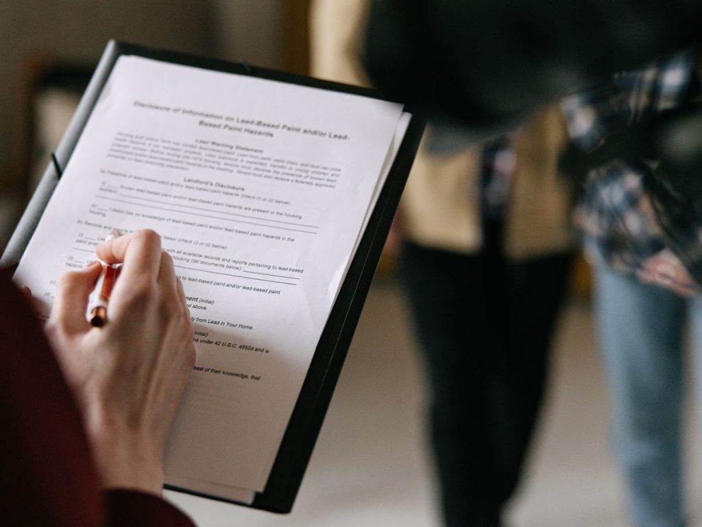 Person reviewing a document on a clipboard with a pen