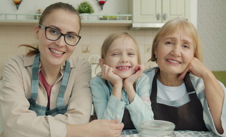 Happy family of three generations smiling together in kitchen
