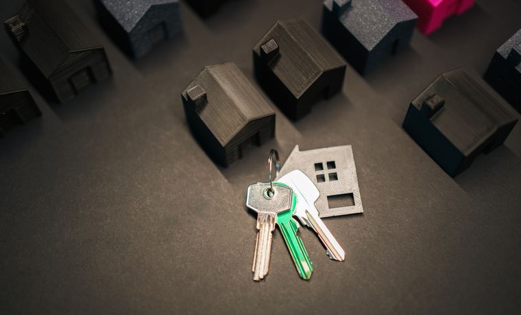 Miniature house models and keys symbolize real estate investment and housing market