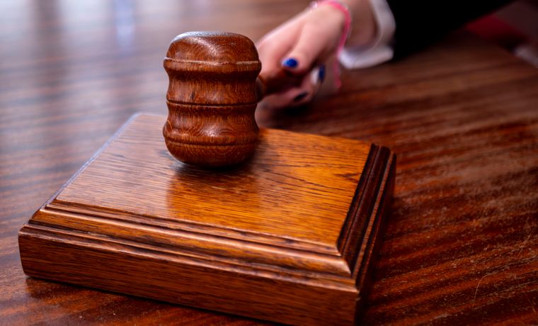 Close-up of a wooden judge's gavel on a desk in a courtroom, symbolizing justice